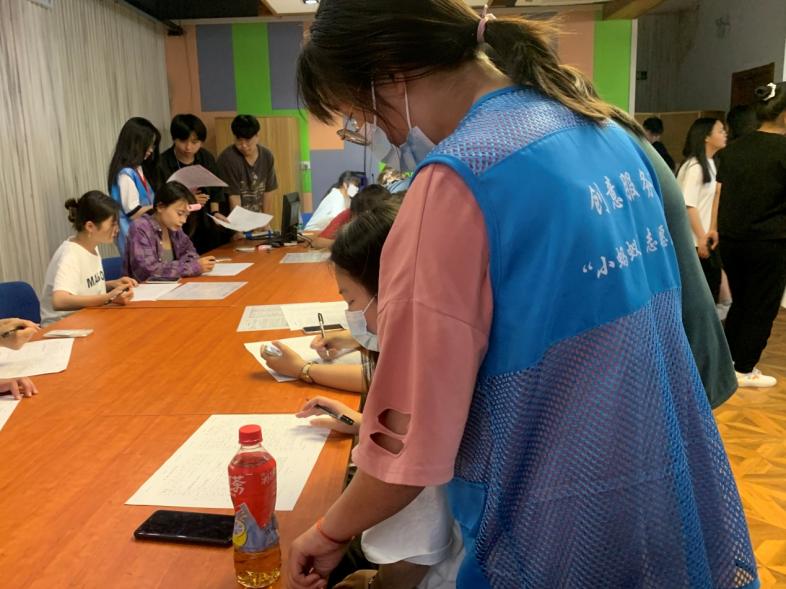 志愿者指导献血学生填写表格.jpg
